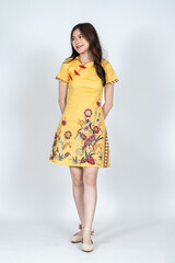 A beautiful asian woman doing a pose while wearing simple yellow chinese dress