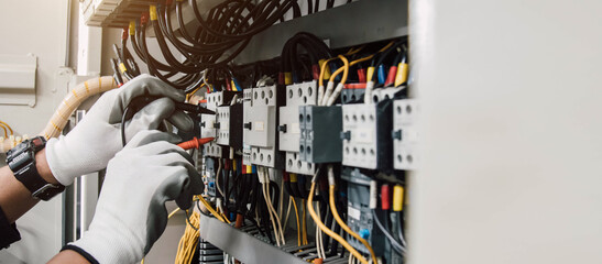 Fototapeta Electrician engineer tests electrical installations and wires on relay protection system. obraz