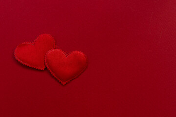 background for Valentines Day design. on a red textured background satin 2 hearts. valentine's day concept, place for text
