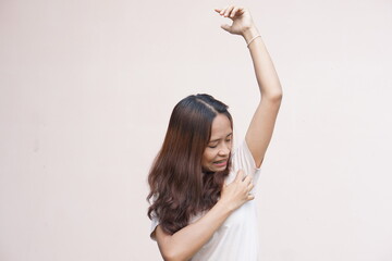 Asian women itching in their armpits.
