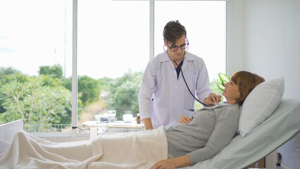 Portrait of caucasian doctor check up body of sick patient on bed in hospital in medical and...