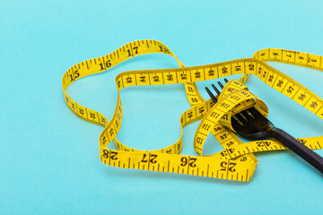 Image of diet concept using tape measure and fork