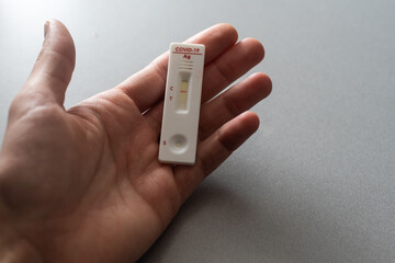 Hand holding rapid Coronavirus Covid-19 negative test device with negative test result