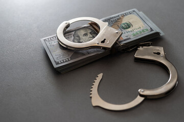 The handcuffs are on hundred-dollar bills. Power and bribery. Criminal ransom. Criminal earnings. Business concept. The concept of wealth