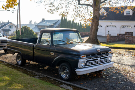 Black Ford F100 Pickup. 1965 retro Ford parked at the street side on sunny autumn day. Snohomish, WA, USA - October 2022