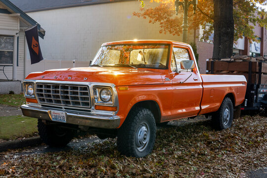 Orange Ford F250 custom Pickup. 1979 retro Ford parked at the street side on sunny autumn day. Snohomish, WA, USA - October 2022