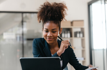 Young African American female working with tablet computer on remote project watching webinar....