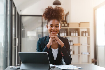 Young African American female working with tablet computer on remote project watching webinar. doing corporate data digital technology analysis.