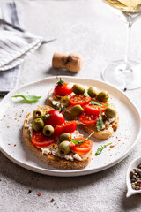 Bruschettas with olives and fresh tomatoes and wineglass