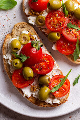 Bruschettas with olives and fresh tomatoes and wineglass