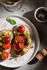 Bruschetta with fresh tomatoes and olives on a plate and wineglass