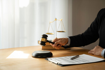 The successful female lawyer or legal advisor holding a judge's hammer in the formal office with a document signing contract. Power of attorney. Business lawyer concept.