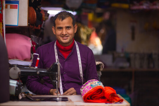 Portrait of a cheerful tailor working in his workshop