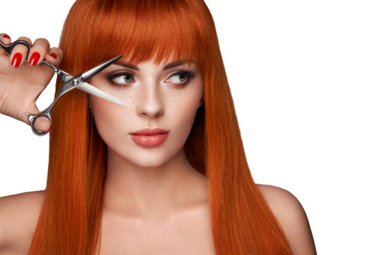 Beautiful young woman with a bright makeup and a smooth long hair holds metal scissors. Model with red hair. Hair salon, haircut. Care and beauty hair products. Perfect make-up