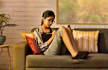 Portrait of a girl studying in living room at home