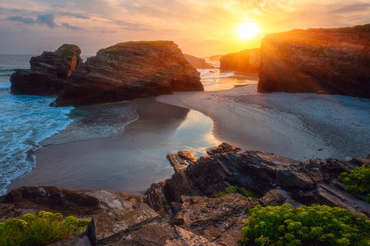 Cathedrals beach (Playa de las Catedrales) or Praia de Augas Santas at sunrise, amazing landscape with rocks on the Atlantic coast and colored sky, Ribadeo, Galicia, Spain. Outdoor travel background