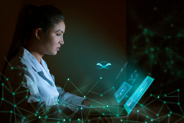 Businesswoman working on laptop computer with icons on virtual screen