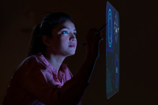 Businesswoman working with icons on virtual screen