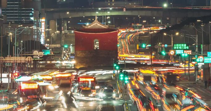 Cityscape of Taipei, the vibrant capital city of Taiwan, with light trails of busy traffic dashing before the historical site "North Gate" or "Chengen Gate" amid modern buildings & office towers