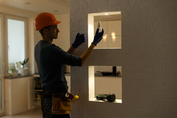 Electrician installs lamp lighting and spot loft style