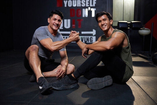 young athletic men meeting in the gym and shaking hands after workout