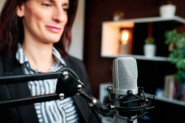 Woman preparing to broadcast or record a podcast in her home studio.
