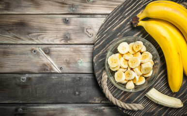 Bananas and banana slices in a glass bowl on the old dressing.