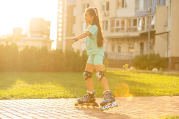 little cute happy girl rollerblading through the city streets