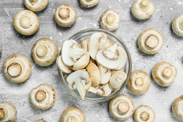 Pieces of fresh mushrooms in the bowl and whole mushrooms.