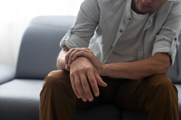 Man's arm touches a painful wrist caused by work.
