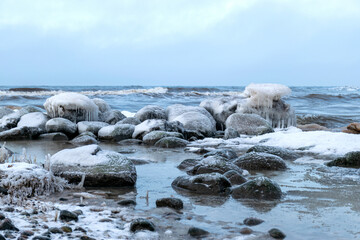 different ice formations on rocks on the seashore, ice texture, wind, water and ice working together