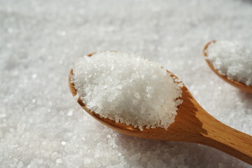 Fototapeta na wymiar Spoon of coarse salt with coarse salt background