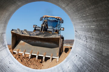 Bulldozer machine is leveling construction site. Earthmover with caterpillar is moving earth....