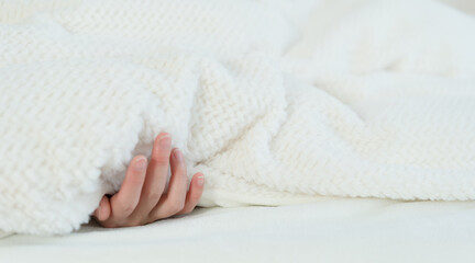 Fototapeta na wymiar The woman's hand in bed