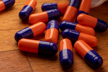 An image of pills on a wooden surface, showcasing the use of natural and organic remedies for treatment - 561214096