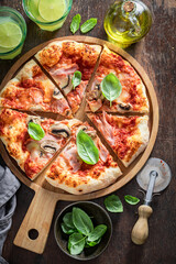 Traditional Capricciosa pizza made of ham and cheese. Italian pizza.