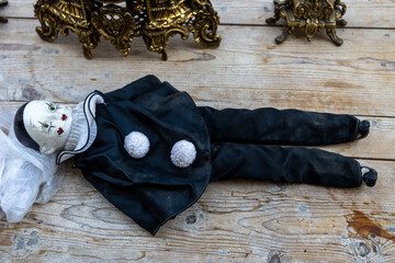 A hundred-year-old vintage rag doll Pierrot lies on the table