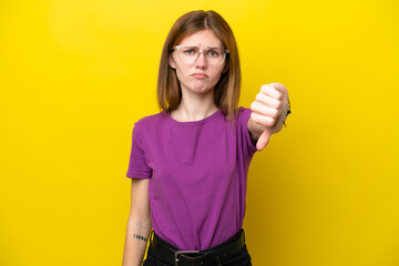 Fototapeta premium Young English woman isolated on yellow background showing thumb down with negative expression