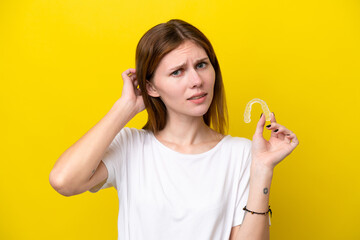 Young English woman holding invisible braces having doubts