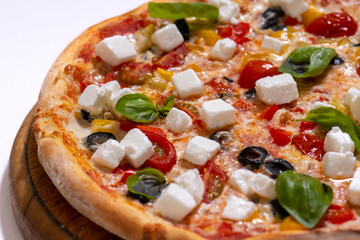 freshly baked pizza with feta cheese slicers on white background