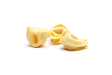 Tortellini stuffed pasta isolated on white background, closeup. Tortellini with raw prosciutto. Italian food