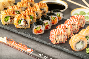 Sushi set of various products on a black stone plate