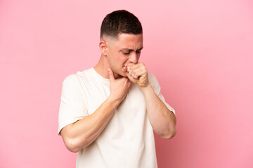 Young Brazilian man isolated on pink background coughing a lot