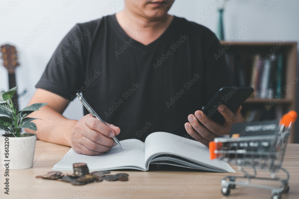 Aufkleber man using smartphone and taking notes in planning. which is payment credit card online, sits on the 