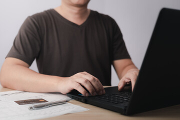 Men use laptop computers and credit card for business commerce, which is payment online, sits on the chair in the living room at home on a laptop. The concept of finance and online shopping.