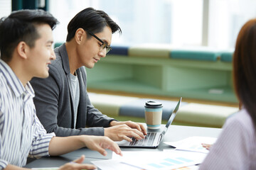 businessman using laptop computer and meeting about work or project with colleague in the office