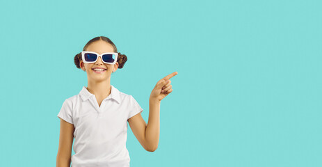 Happy casual Caucasian girl teen in funny sunglasses with smile points finger at copy space for...