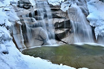 Vivid view of 'Mumlavský vodopád' waterfall in Harrachov, Czech Republic in winter. Beautiful scenery, blurred, soft water.