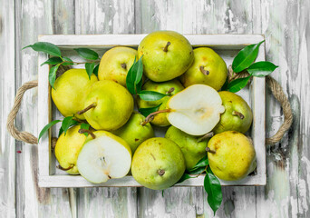 Fresh pears with leaves on tray.