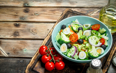 Fototapeta premium Vegetable salad. Tomato, cucumber and quail egg salad with olive oil and Basil.